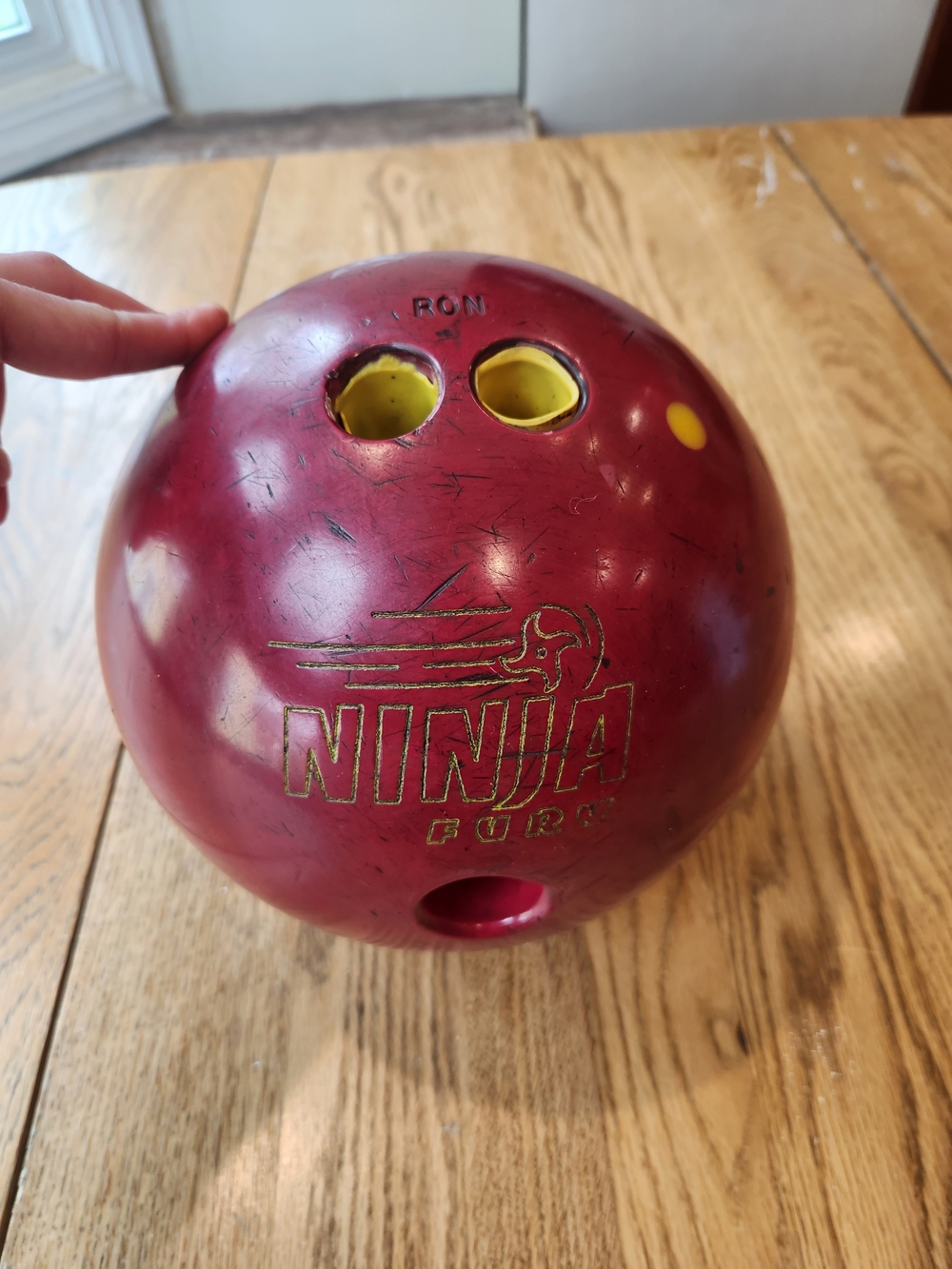 Ninja bowling ball in maroon with yellow inserts